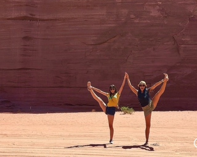 Two women doing yoga poses in the red canyon at Talampaya National Park