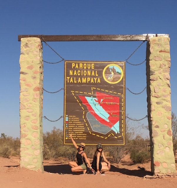 Two women at the Parque Nacional Talampaya entrance sign