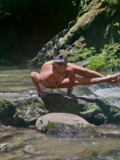 Julia doing yoga on river rocks in Tennessee